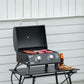 Black tabletop gas grill with open lid, control knobs, and folding frame