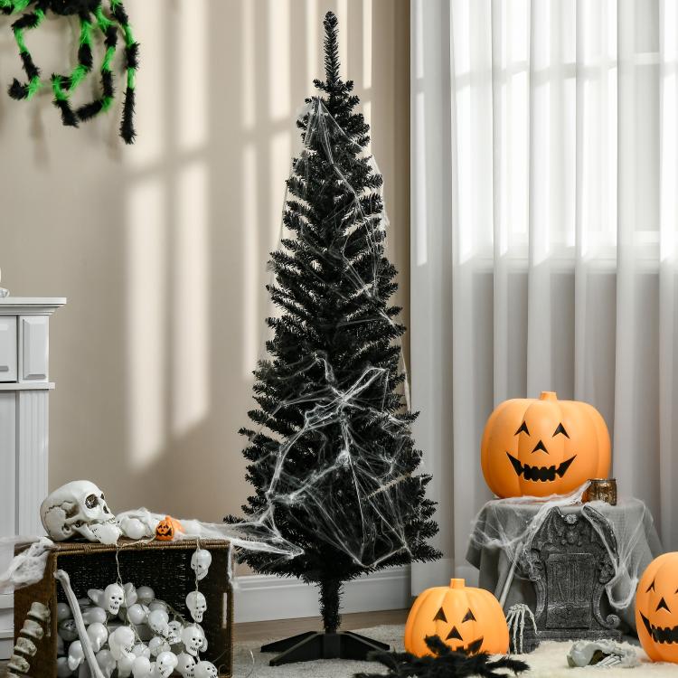Black pencil artificial Christmas tree with spooky Halloween decor around it