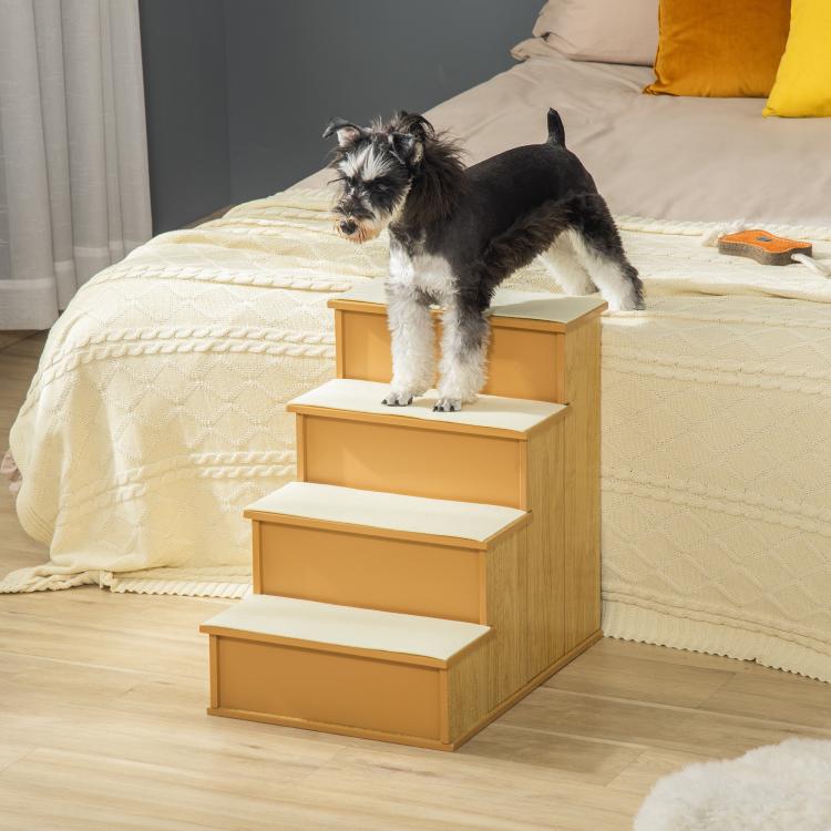 Small dog using natural wood pet stairs with white cushioned steps