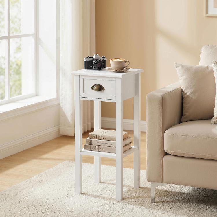 White side table with drawer and open shelf, brass-toned handle next to sofa