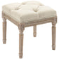 Beige ottoman bench with tufted seat, rounded edges, and carved wooden frame