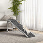 Foldable dog ramp with dark non-slip carpet tread and white side supports in living room