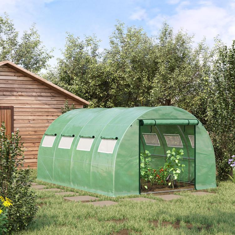 Green tunnel greenhouse with mesh window panels and zippered front door, outdoor yard
