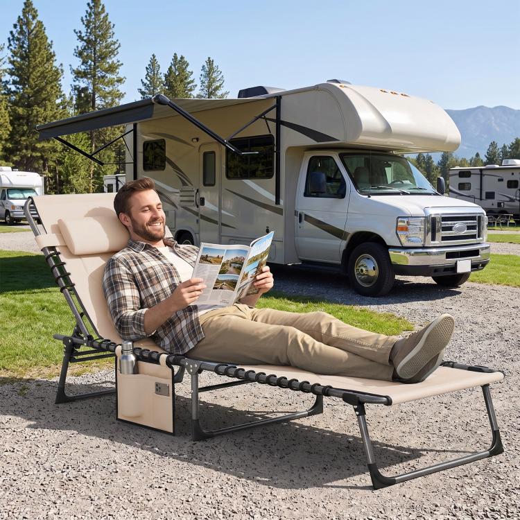Beige padded reclining chaise lounge chair with headrest next to RV campsite