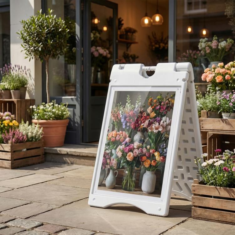 White A-frame sidewalk sign holding a flower bouquet poster behind clear cover