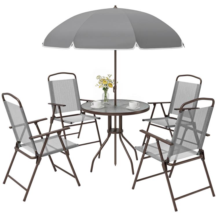 Gray patio dining set with round glass table, umbrella, and four folding chairs