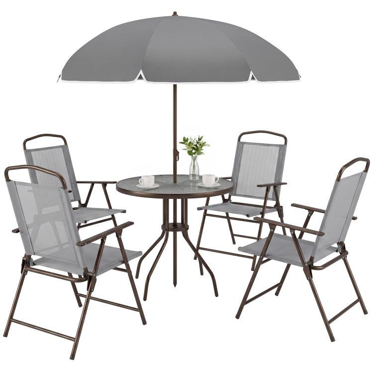 Round glass table with umbrella and four gray folding patio chairs