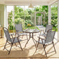 Indoor patio dining set with umbrella, round glass table, and four gray folding chairs