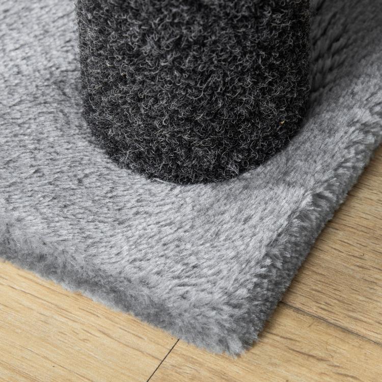 Grey fabric cat tree scratching step with curved carpet edge