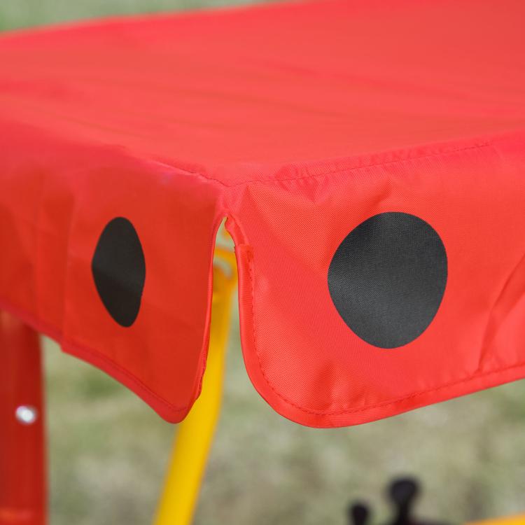 Kids red canopy swing with black dot panels and ladybug accents