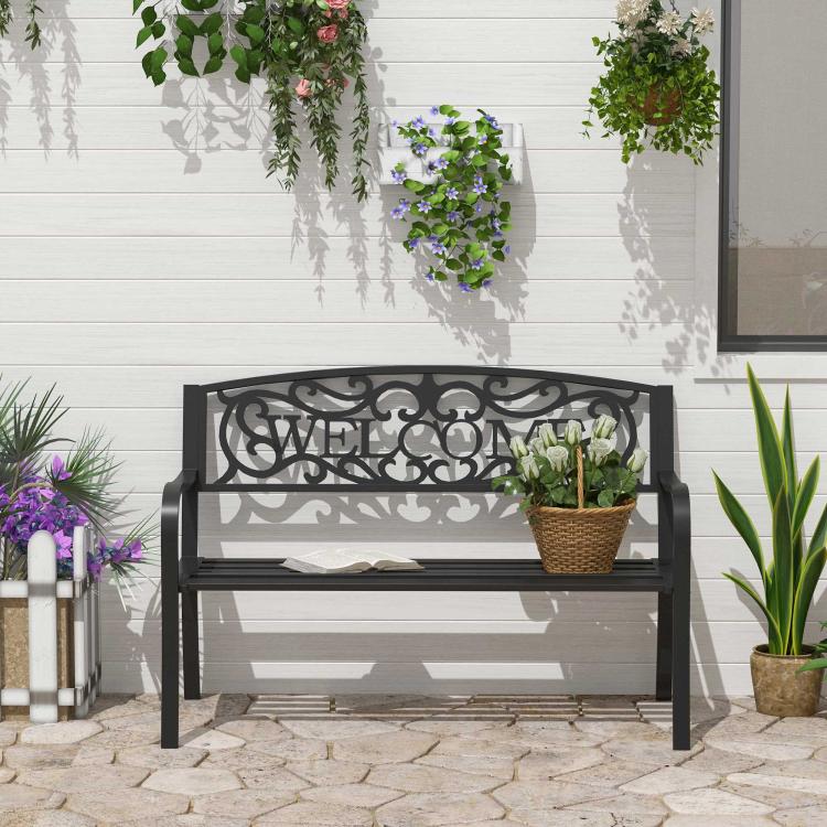 Black outdoor garden bench with vine "WELCOME" backrest and slatted seat.