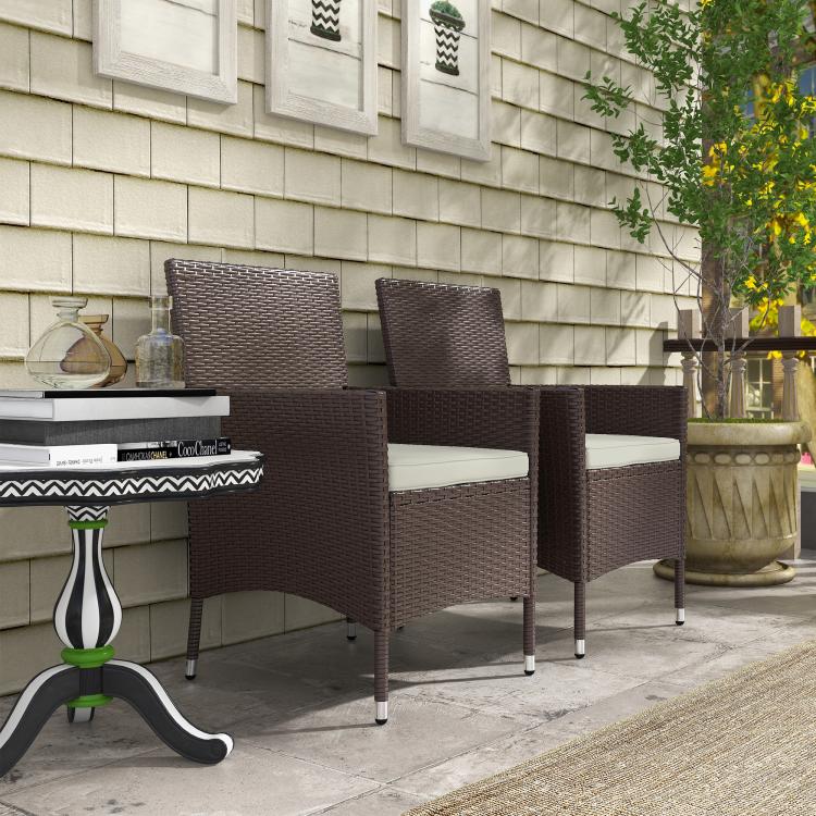 Dark coffee wicker outdoor dining chairs with white seat cushions and padded armrests
