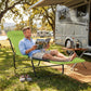 Green folding chaise lounge chair on outdoor grass with black steel legs