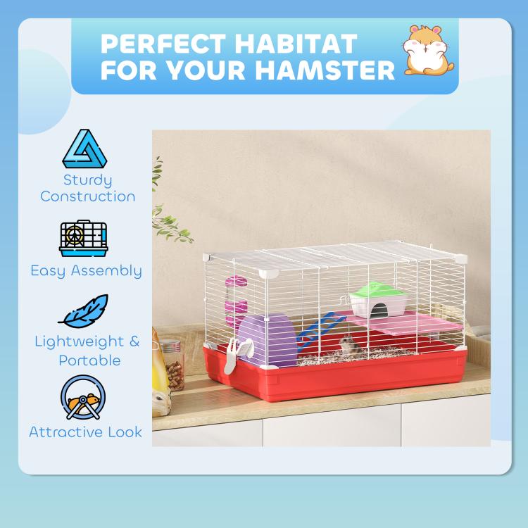 Hamster cage on a table with red base, white wire walls, wheel, ramp, and house