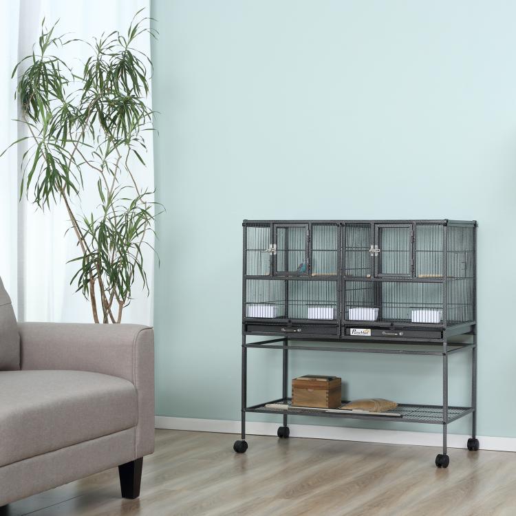 Divided metal bird cage with wheeled base and two top compartments