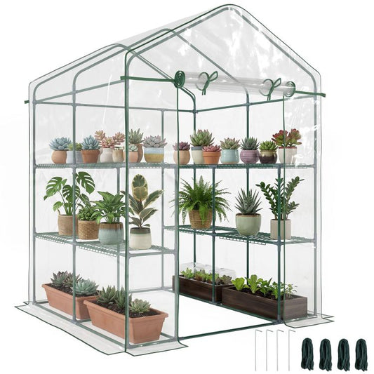 Portable clear mini walk-in greenhouse with green frame and 3-tier shelves, plants inside