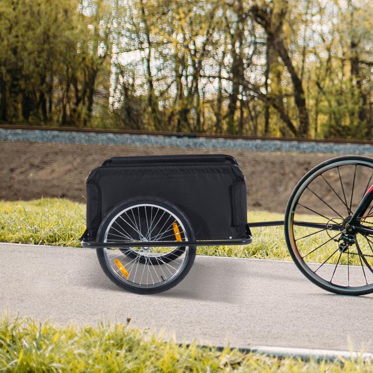 Two-wheel bicycle cargo trailer with black cover on road, metal hitch visible