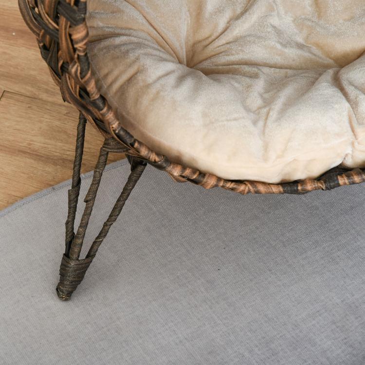 Lower corner of elevated woven cat bed showing legs and cream cushion edge