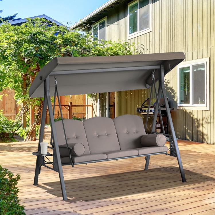 3-seat outdoor porch swing glider with overhanging canopy and taupe cushions on patio