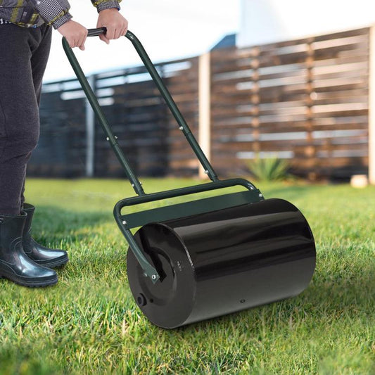 Push lawn roller with black steel drum on grass, dark green handle