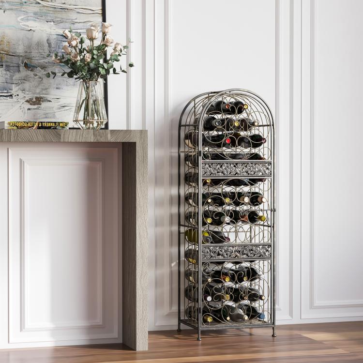 Antique bronze wine bottle rack with bottles, arched cage and decorative scrollwork