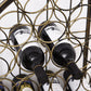 Dark wine bottles held in place by a bronze wrought-iron ring grid rack