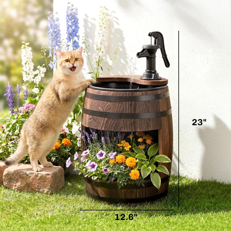 Rustic wooden barrel water fountain with black pump spraying water, planted with colorful flowers