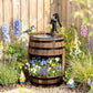 Rustic wooden barrel water fountain with black pump, flowers in front planter openings