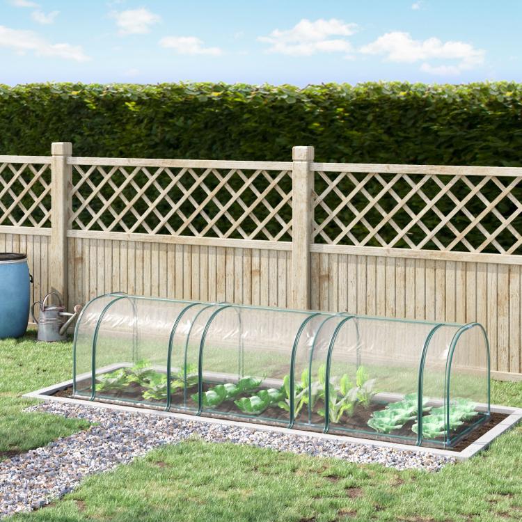 Plastic tunnel greenhouse kit in garden with clear arched cover over planted bed