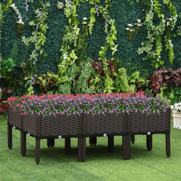 Raised garden bed planter box with dark brown rattan sides and colorful flowers on legs