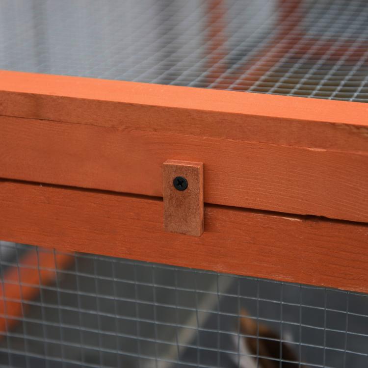 Wooden rabbit hutch corner with black latch/lock on mesh panel frame