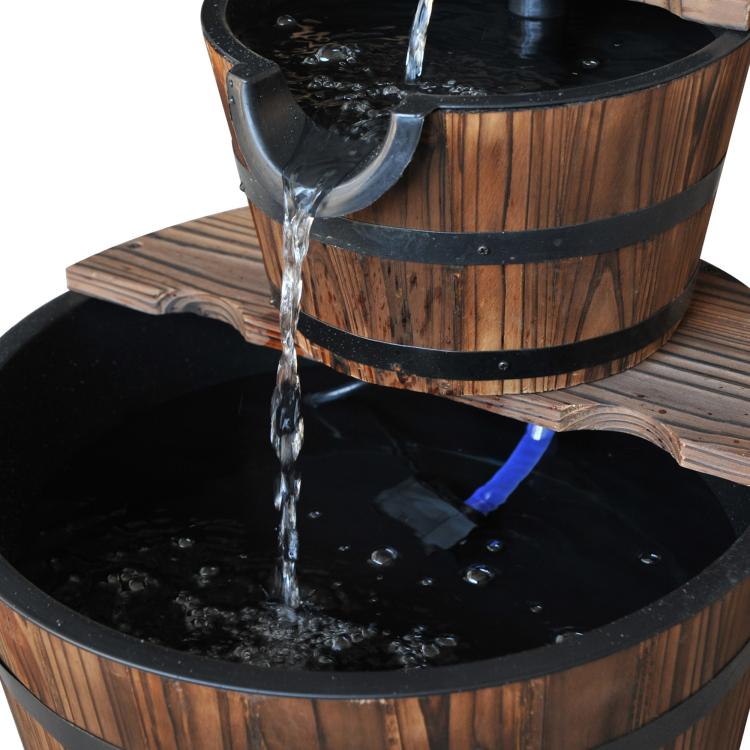 Close-up of two-tier wooden barrel fountain with water pouring into lower basin