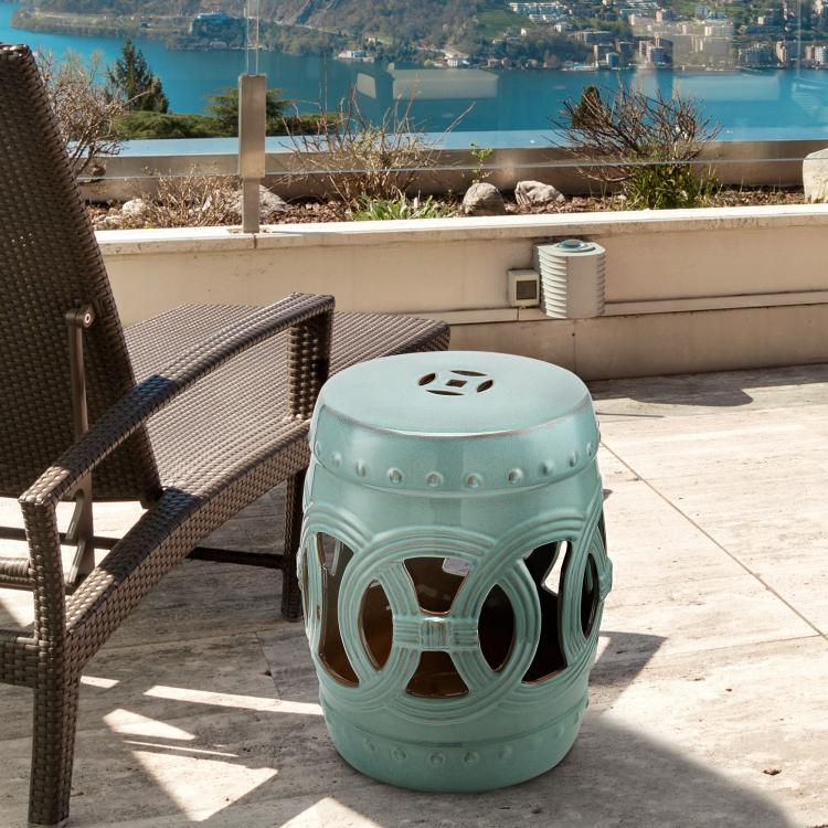 Antique blue ceramic garden stool with cutout double-coin ring pattern, circular seat top.