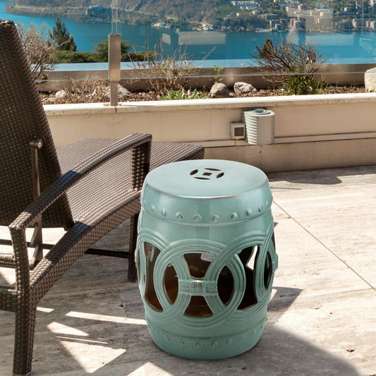 Antique blue ceramic garden stool with cutout double-coin ring pattern, circular seat top.