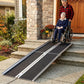 Wheelchair ramp on exterior steps with black anti-slip tread and silver side rails