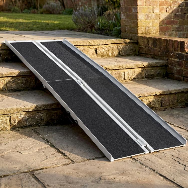 Portable ramp with black grip surface and silver edging, positioned across stone steps