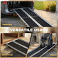 Portable wheelchair ramp extending into doorways, black anti-slip tread on silver frame