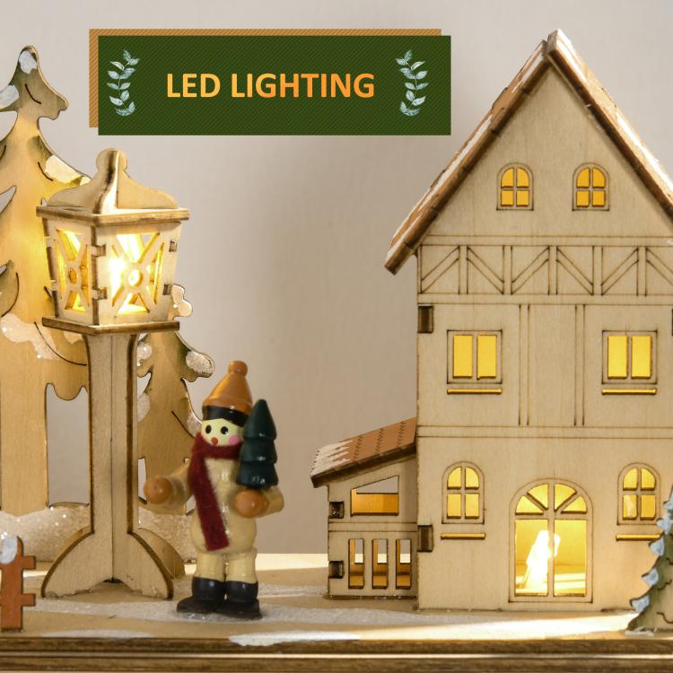 Warm-lit wooden house and lantern ornaments with snowy details, part of the advent display