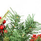 Close-up of pre-lit artificial Christmas tree with green needles and red berries