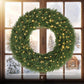 Green pre-lit pine wreath with warm white LED lights, shown in front of windows