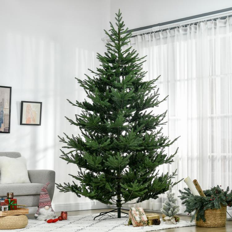 Green artificial Christmas tree with dense branches and metal tripod base