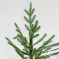 Close-up of green artificial pine branches and needle tips on central stem