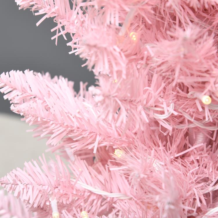 Pink slim artificial Christmas tree branches with warm white LED lights, close-up