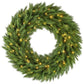 Green pre-lit Christmas wreath close-up with warm yellow LED bulbs