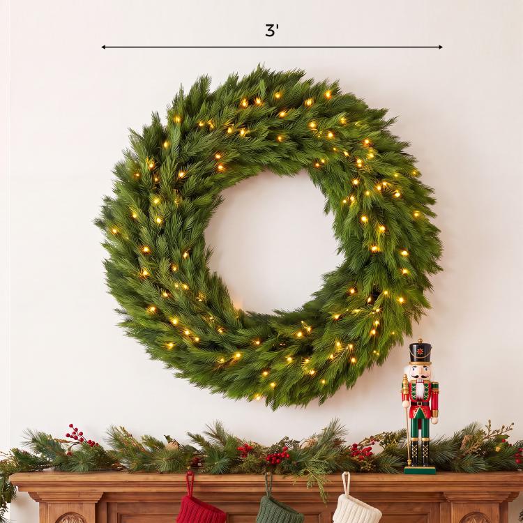 Green pre-lit artificial wreath with warm LED lights, circular evergreen garland ring