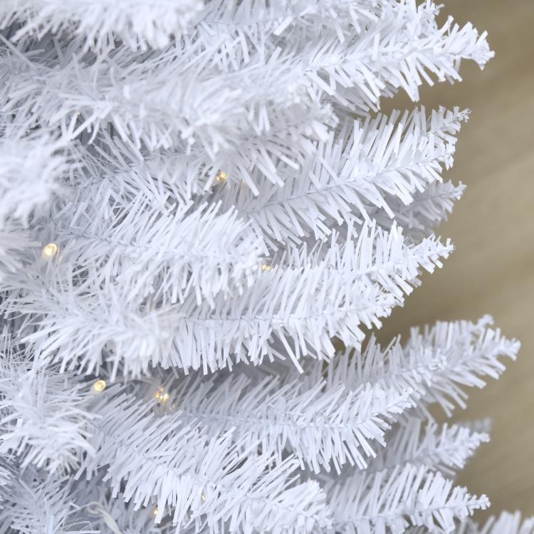 White artificial pencil Christmas tree branches with warm white LED lights, close-up