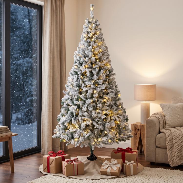 Snow-flocked prelit Christmas tree with warm white lights, full conical profile