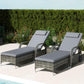 Outdoor chaise lounge chairs with gray cushions and dark wicker armrests, reclined