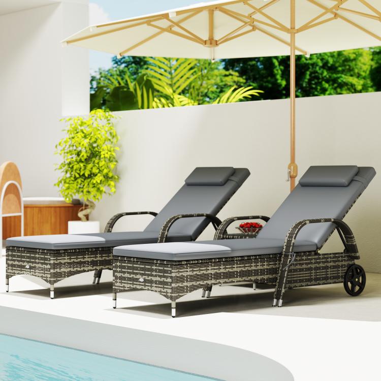 Set of three gray outdoor chaise lounges with dark wicker weave under patio shade