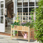 Wooden raised garden bed with trellis, flower planter, and watering can outdoors